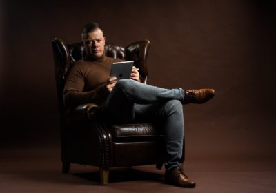 René Ranisch avec un iPad, assis sur un fauteuil club