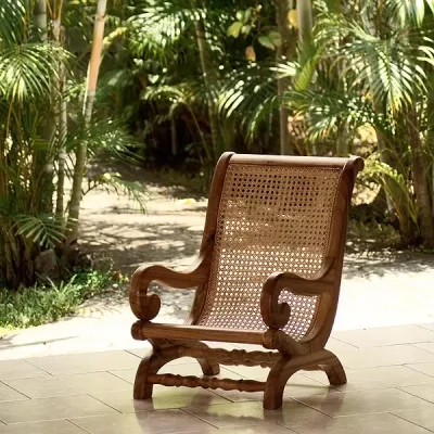 Un fauteuil Créole placé devant une végétation abondante