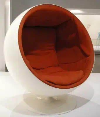 Egg chair with white exterior and orange fabric interior